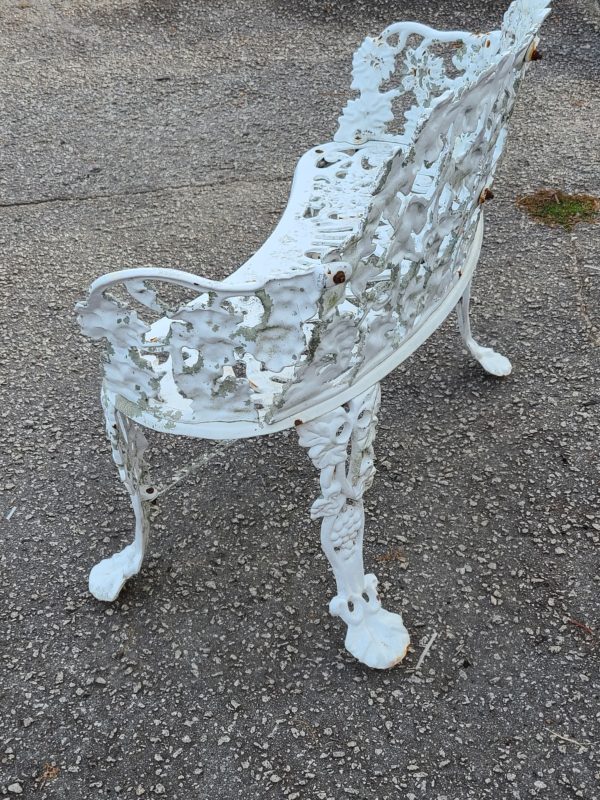 Side view of a white antique iron bench outside