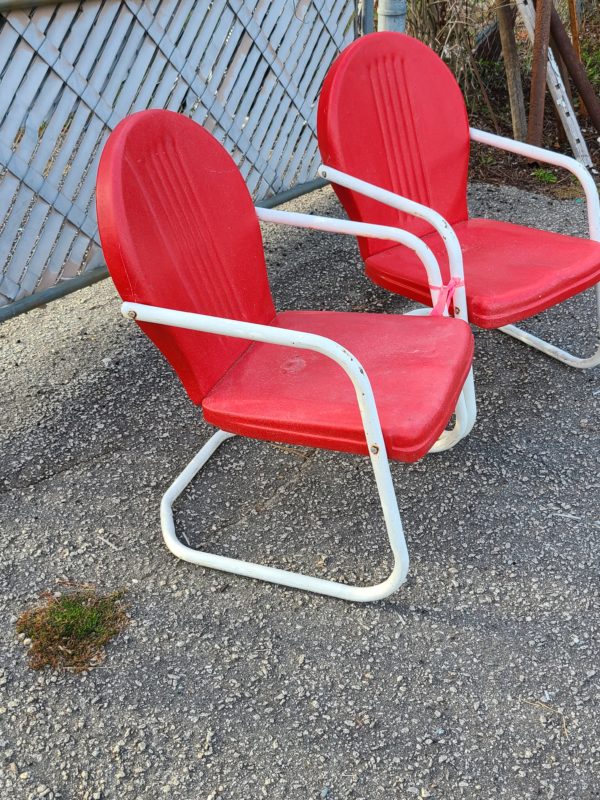 Side view of matching set of red outside chairs